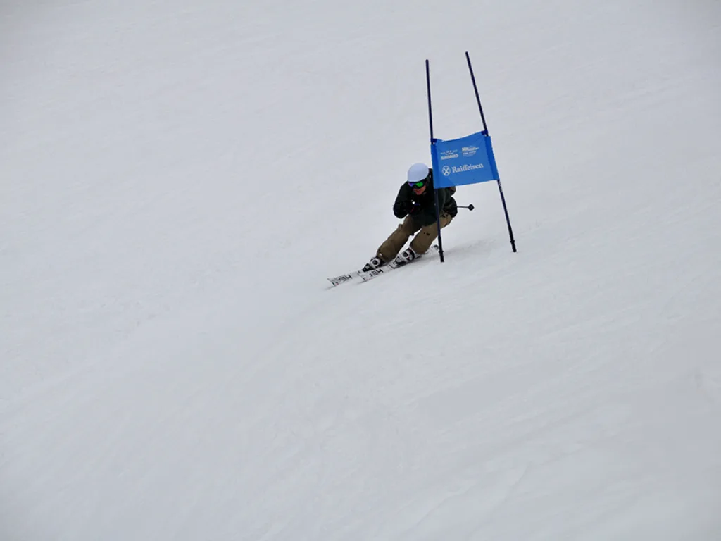 Skifahrer in tiefer Hocke am blauen Tor.